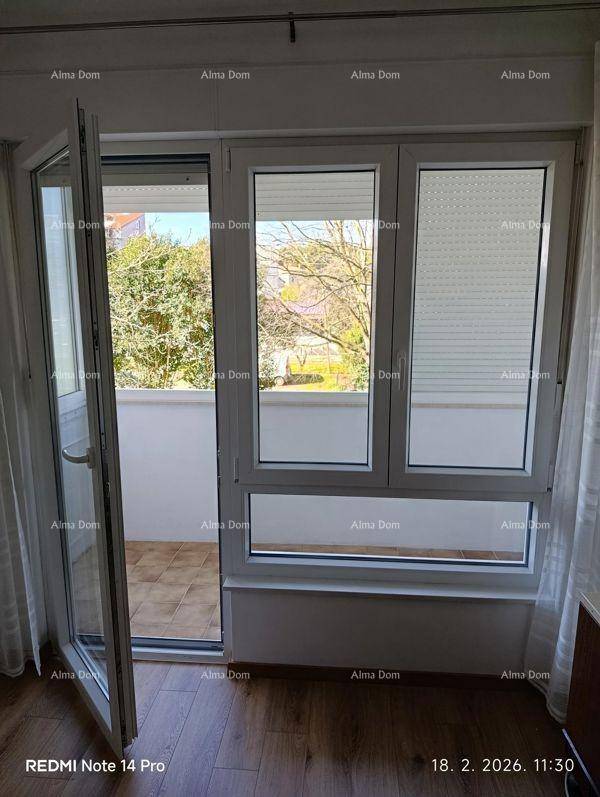 Blick aus dem Schlafzimmer auf den Balkon mit grüner Umgebung und viel Tageslicht.