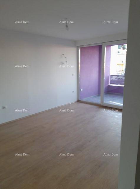 Wohnbereich mit Holzboden und großem Fenster, das auf einen lila gestrichenen Balkon führt.