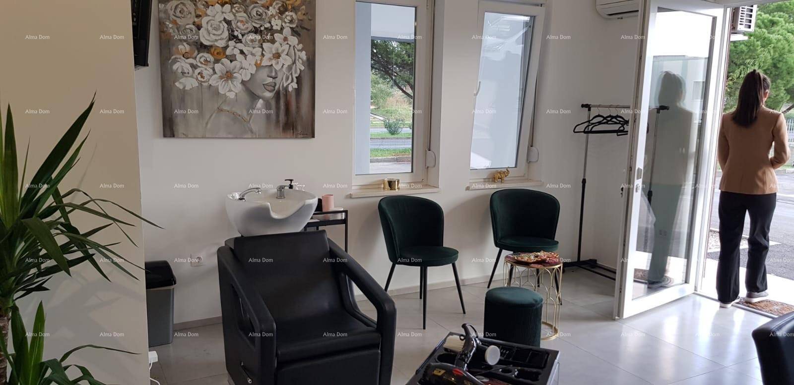 Friseursalon mit Waschbecken, dunklen Stühlen und viel Tageslicht durch die Eingangstür.
