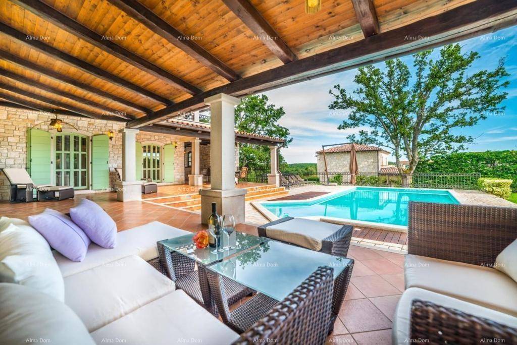 Geräumige überdachte Terrasse mit bequemen Loungemöbeln und weitem Blick auf den Poolbereich.