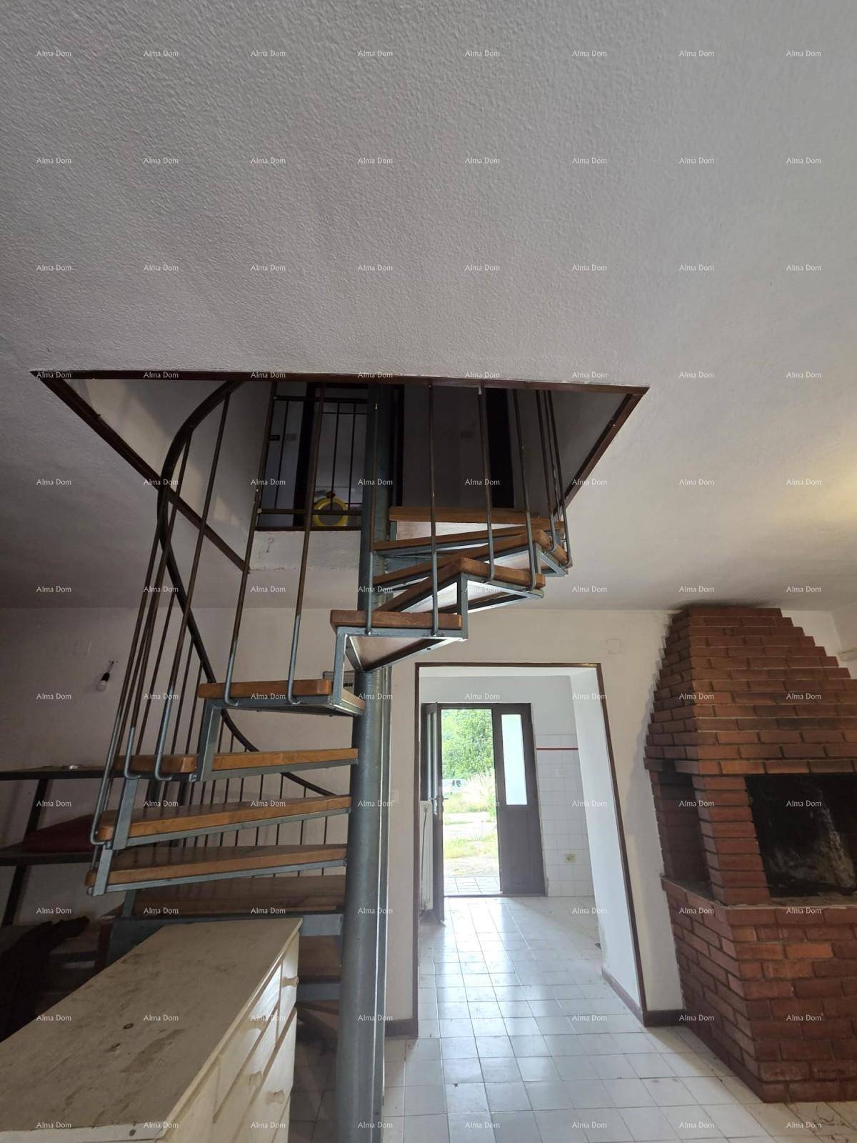 Wohnbereich mit Wendeltreppe zum Obergeschoss und einem gemauerten Kamin.