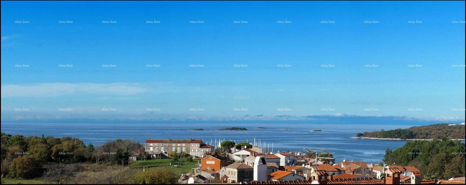 Panoramablick auf eine Küstenstadt mit Meer, Inseln und fernen Bergen.