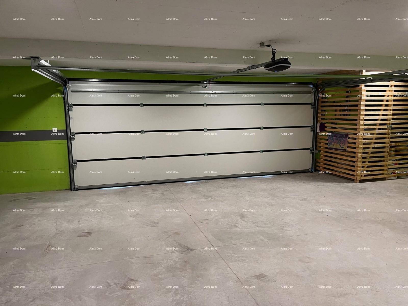 Innenansicht einer Garage mit großem Sektionaltor und viel Stauraum durch Holzpaletten.