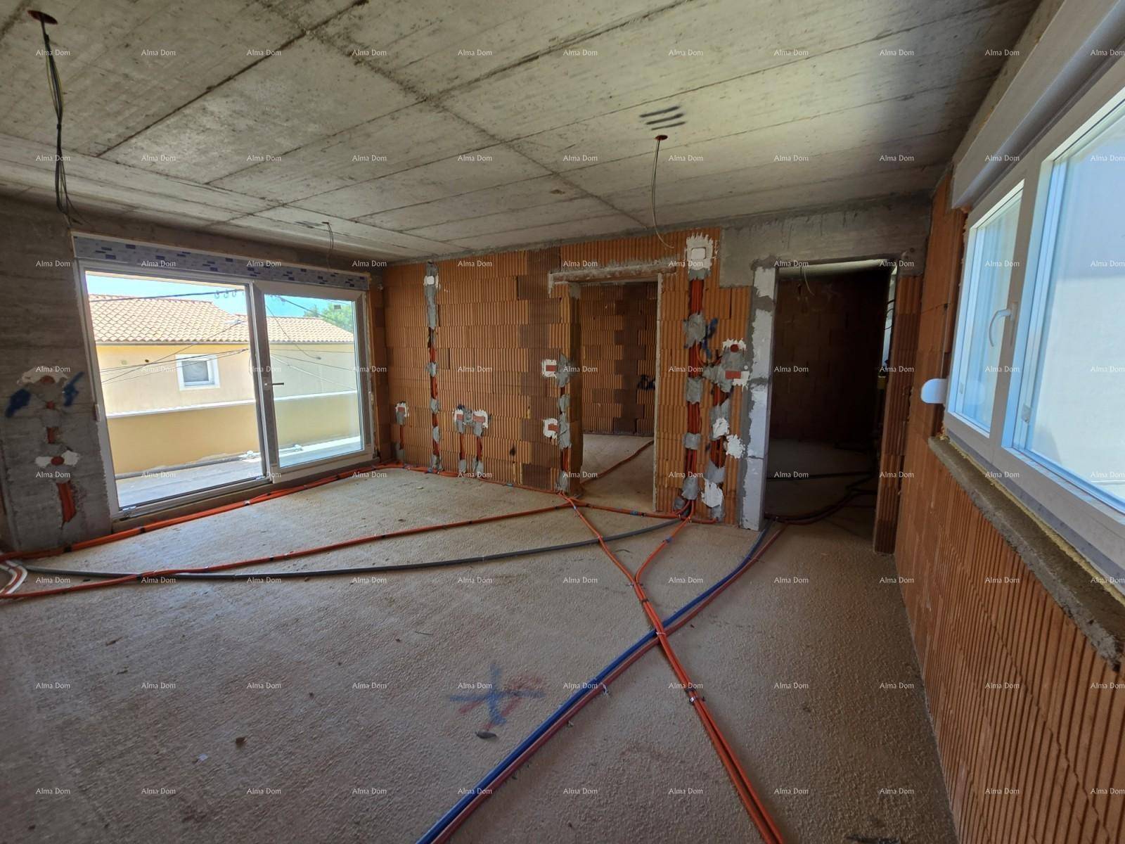 Großer Wohnbereich im Rohbau mit Zugang zu einem Balkon und sichtbaren Leitungen.
