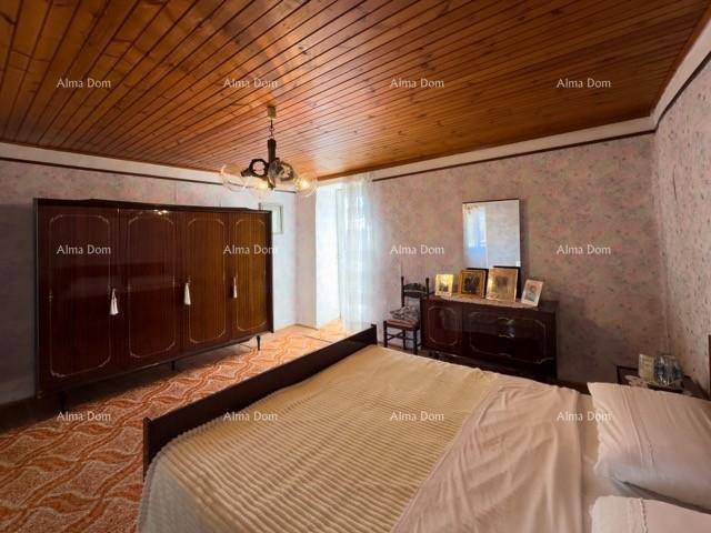 Geräumiges Schlafzimmer mit Holzdecke, großem Kleiderschrank und gemustertem Teppichboden.