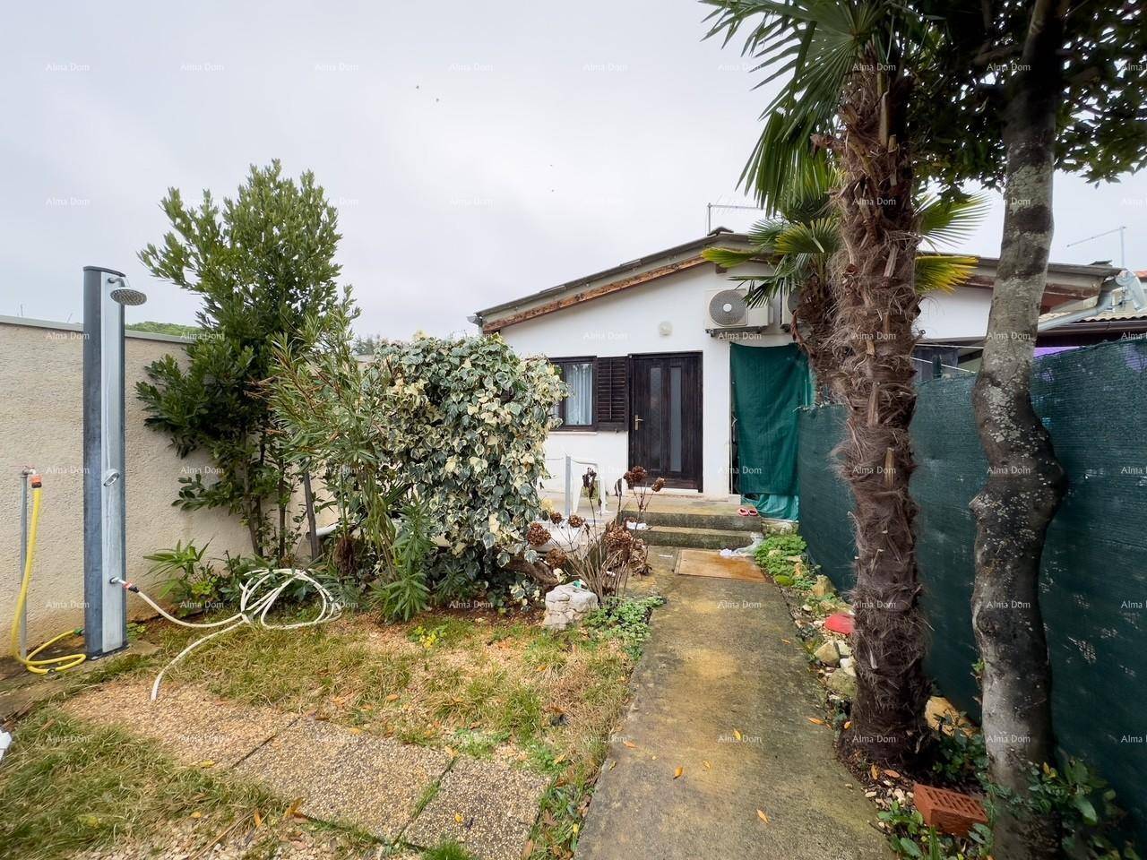 Gartenweg führt zum Haus mit einer Außendusche und mediterraner Bepflanzung.