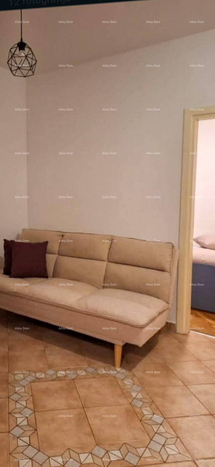 Gemütliches beiges Sofa in einem Raum mit gefliestem Boden und Zugang zu einem weiteren Zimmer.