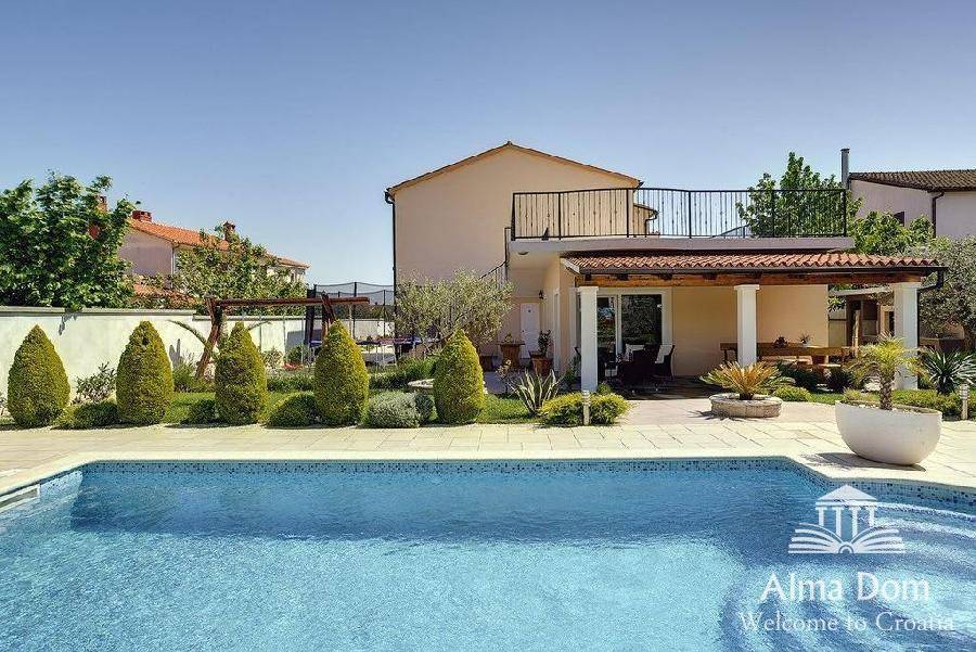 Außenbereich mit großem Pool, gepflegtem Garten und Blick auf das Wohnhaus.