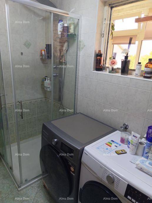 Badezimmer mit Duschkabine, Waschmaschine und Fenster für natürliches Tageslicht.
