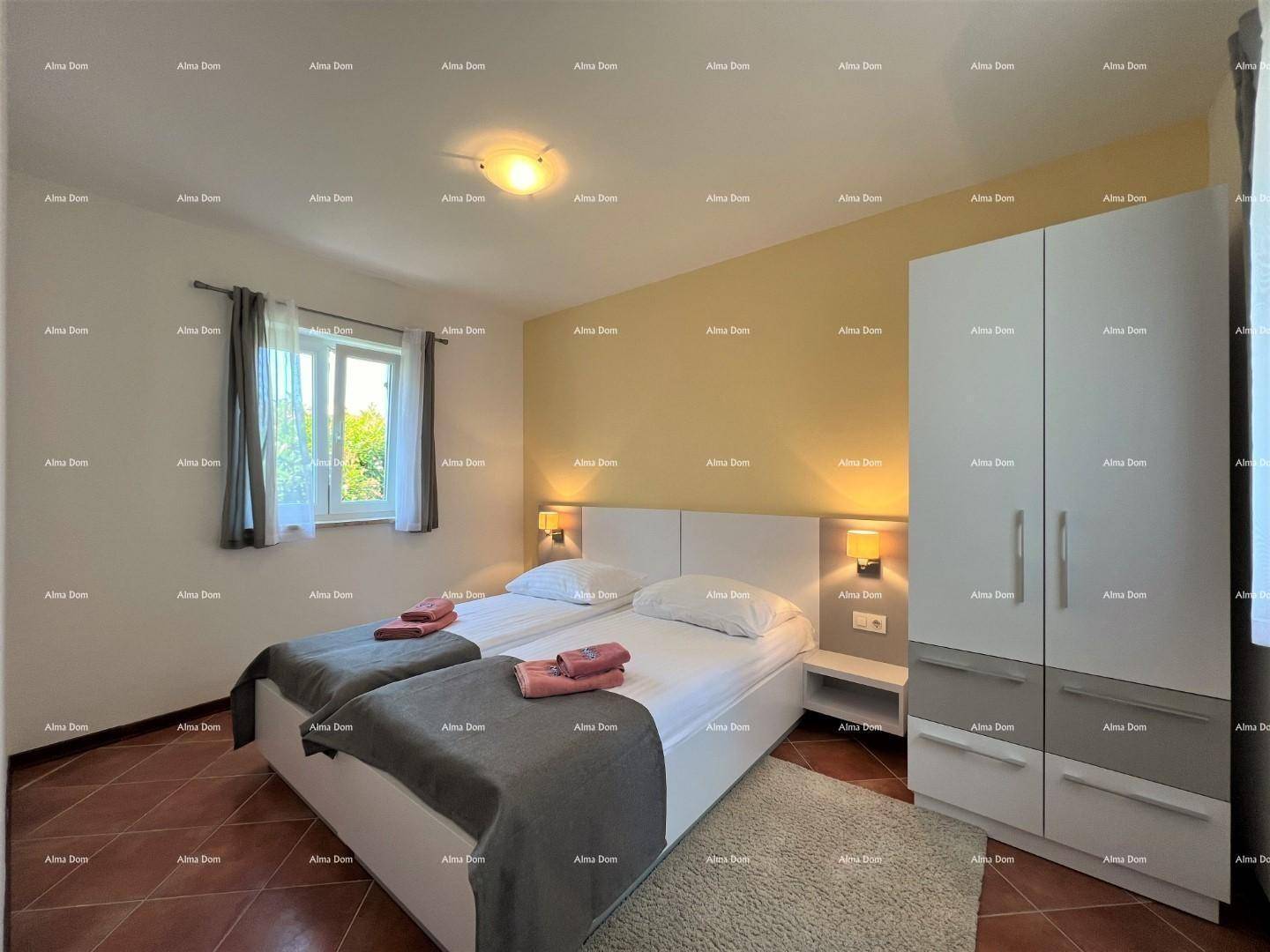 Geräumiges Schlafzimmer mit zwei Einzelbetten, Kleiderschrank und Terrakottafliesenboden.