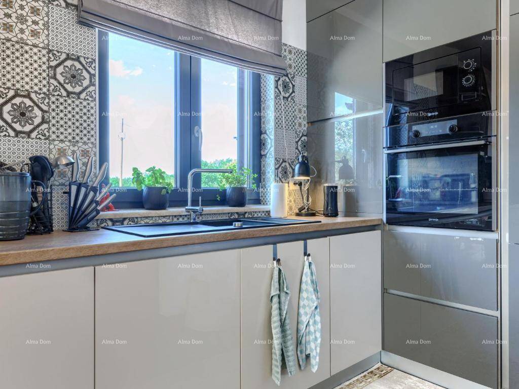 Helle Küchenzeile mit Spülbecken unter dem Fenster und modernen Armaturen.