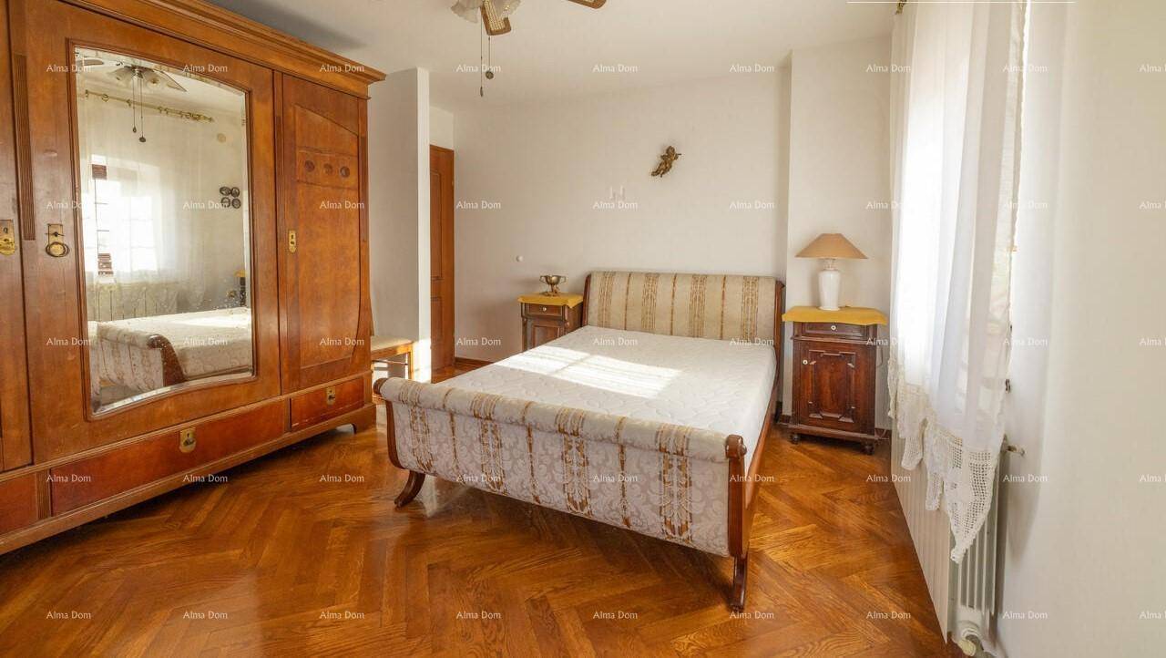 Schlafzimmer mit klassischem Holzbett, großem Kleiderschrank und glänzendem Parkettboden.