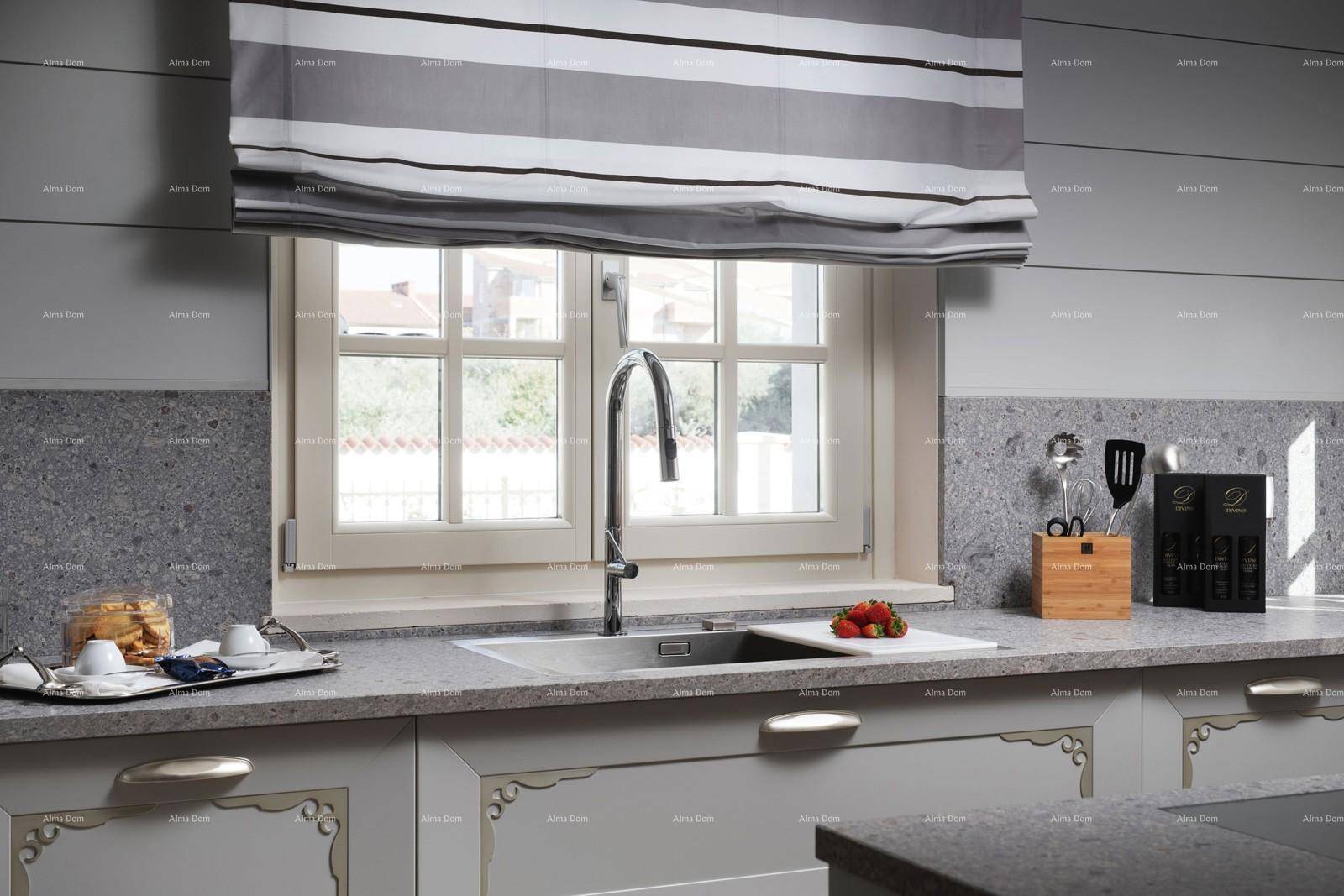 Küchenzeile mit Spülbecken unter dem Fenster und grauen Arbeitsflächen.