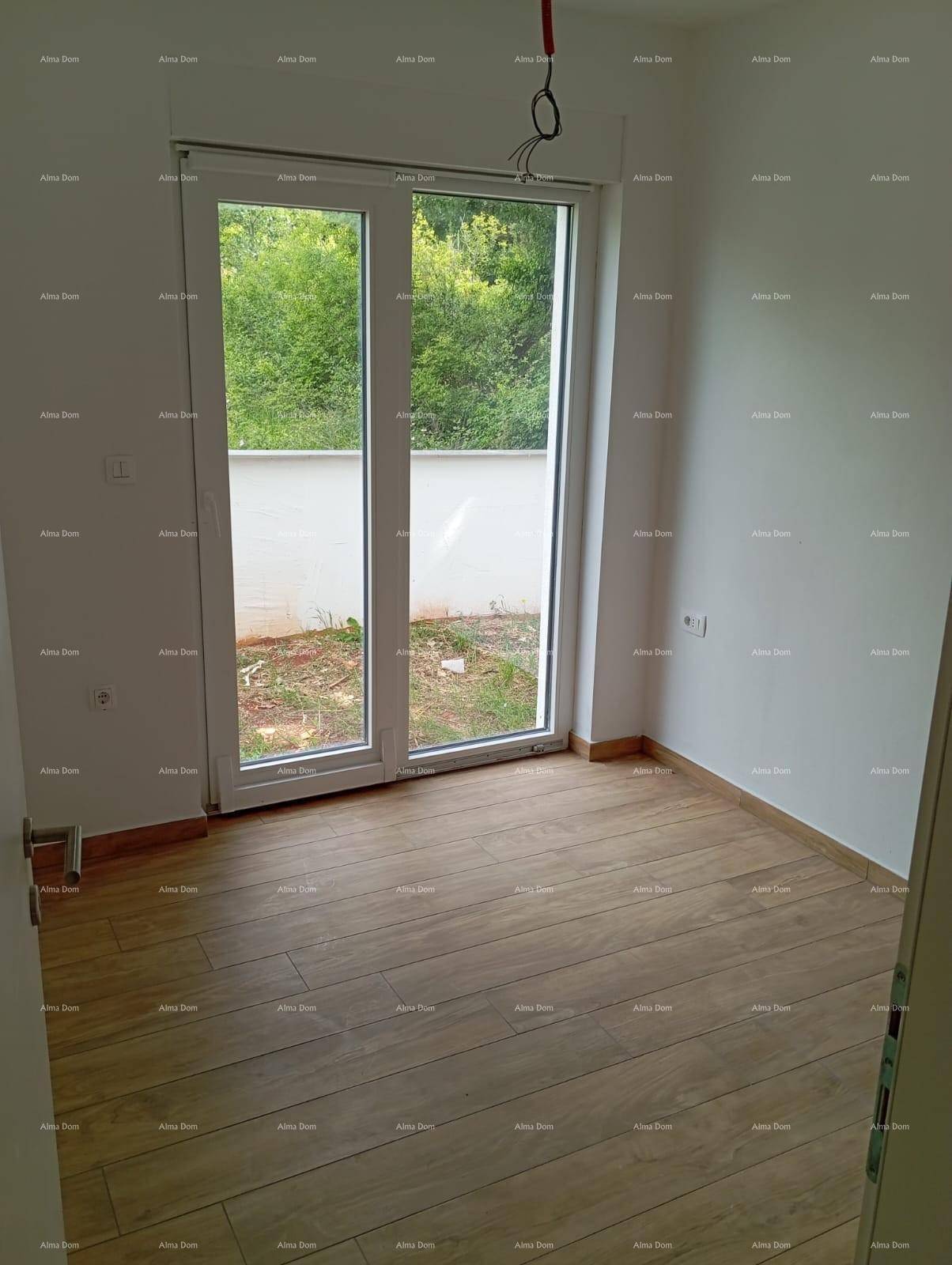 Helles Zimmer mit Holzoptik-Fliesenboden und großer Glastür, die zu einem unfertigen Außenbereich führt.
