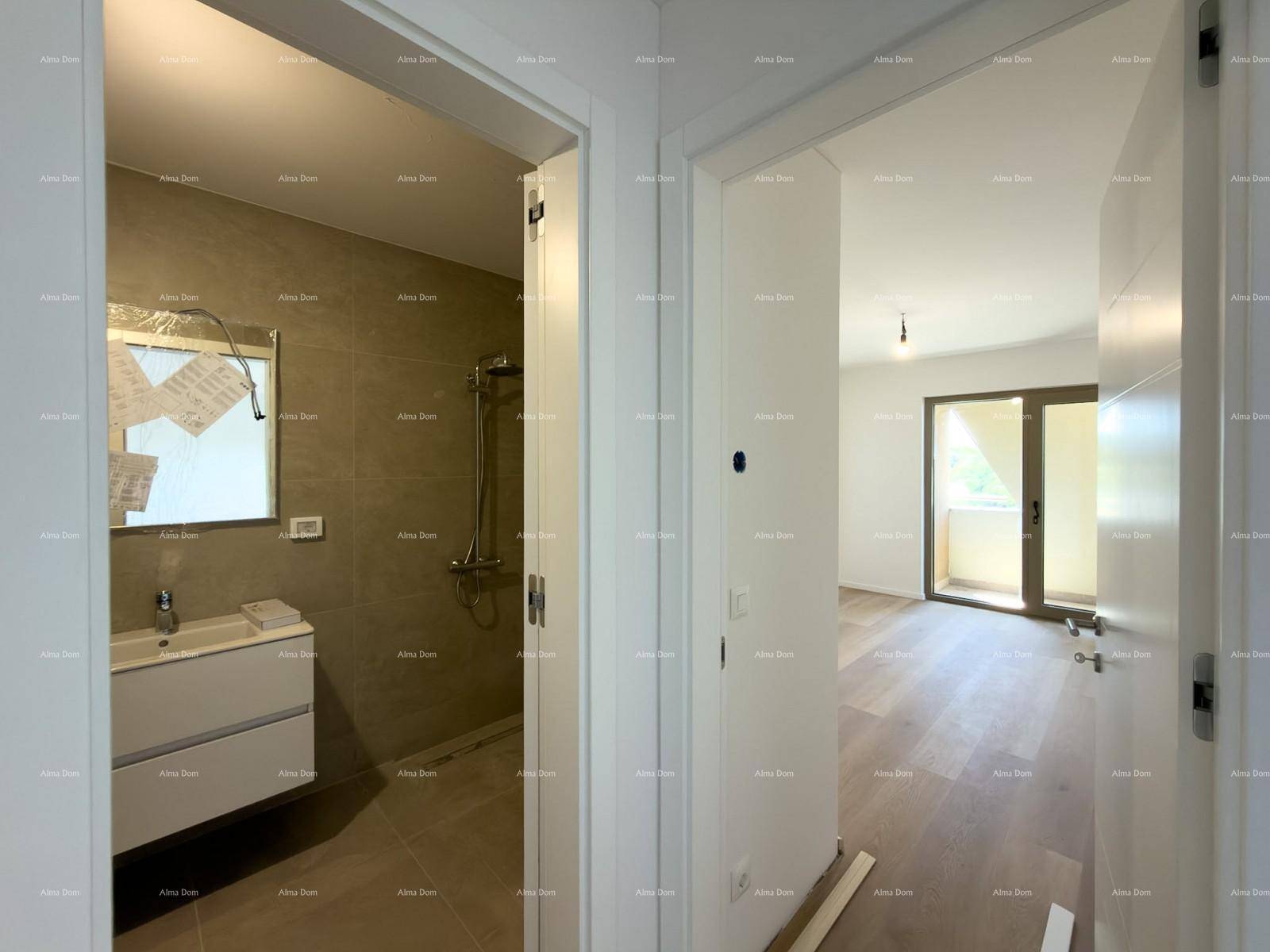 Flur mit Blick in ein modernes Badezimmer und ein helles Zimmer mit Balkonzugang.