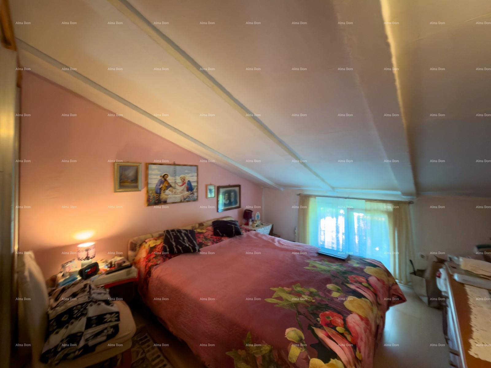 Helles Schlafzimmer mit rosa Wänden, Doppelbett und Holzbalkendecke, bietet eine warme Atmosphäre.