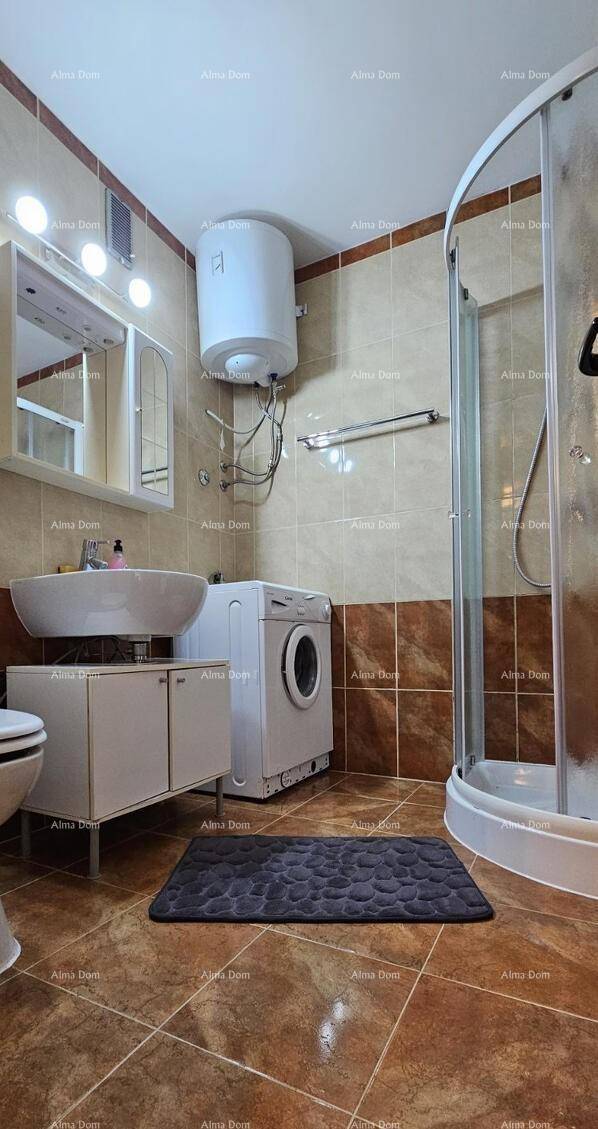 Badezimmer mit Duschkabine, Waschbecken und Waschmaschine.
