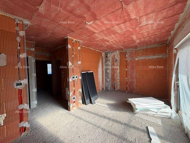 Rohbau eines Zimmers mit sichtbaren Ziegelwänden und vorbereitetem Boden.