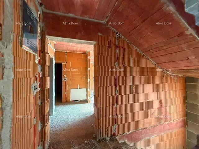 Flurbereich im Rohbau mit Ziegelwänden und Treppenansatz.