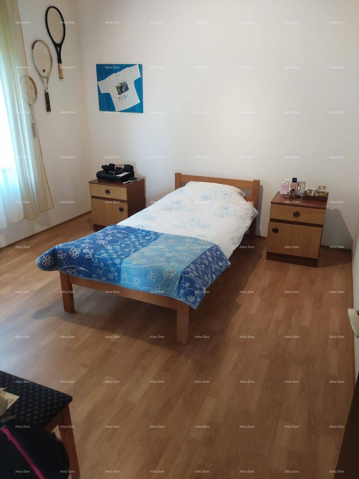 Helles Schlafzimmer mit Holzbett, Nachttischen und Laminatboden, einfach eingerichtet.