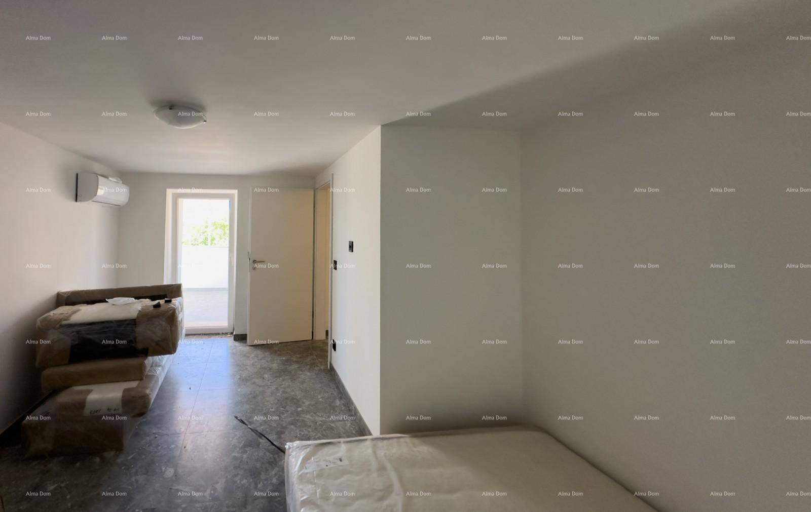 Schlafzimmer mit Klimaanlage und Zugang zu einem Außenbereich, ausgestattet mit grauen Fliesen.