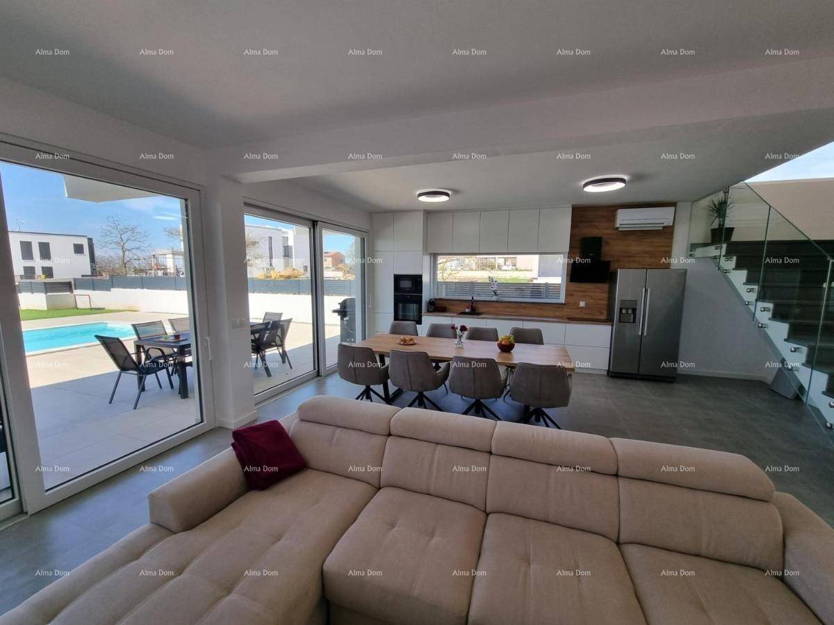 Heller Wohnbereich mit Sofa, offener Küche und großen Schiebetüren zur sonnigen Terrasse.