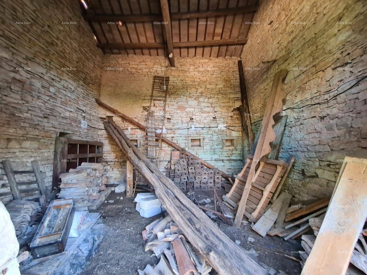 Rustikaler Innenraum mit unverputzten Steinwänden und Holzbalken, gefüllt mit Baumaterialien.