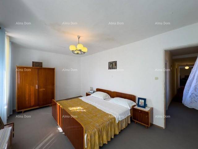 Geräumiges Schlafzimmer mit Doppelbett, Holzmöbeln und Zugang zu einem Flur.