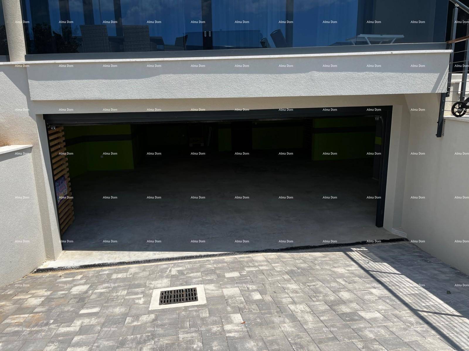 Einfahrt zur Garage mit gepflastertem Bereich und offener Garagentür.