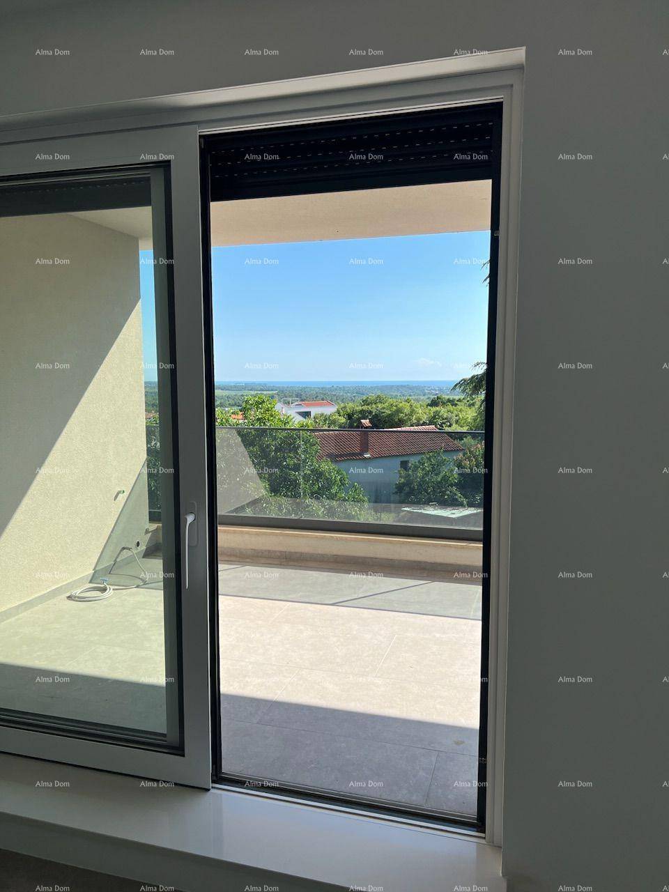 Weitblick aus einem großen Fenster auf die umliegende Landschaft und das Meer in der Ferne.