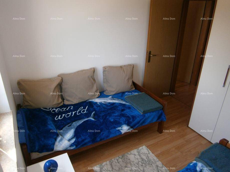 Schlafzimmer mit Einzelbett, Holzboden und weißem Kleiderschrank.