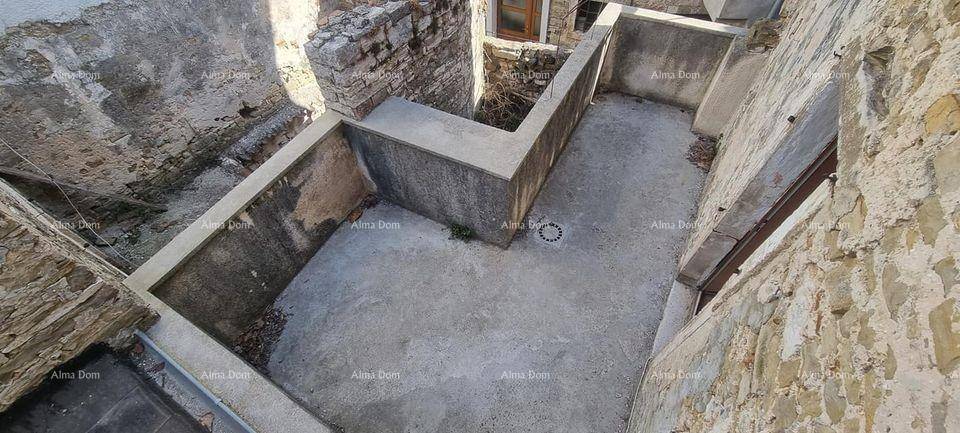 Leerer, ummauerter Außenbereich mit Betonboden und alten Steinmauern, ideal für einen kleinen Innenhof.