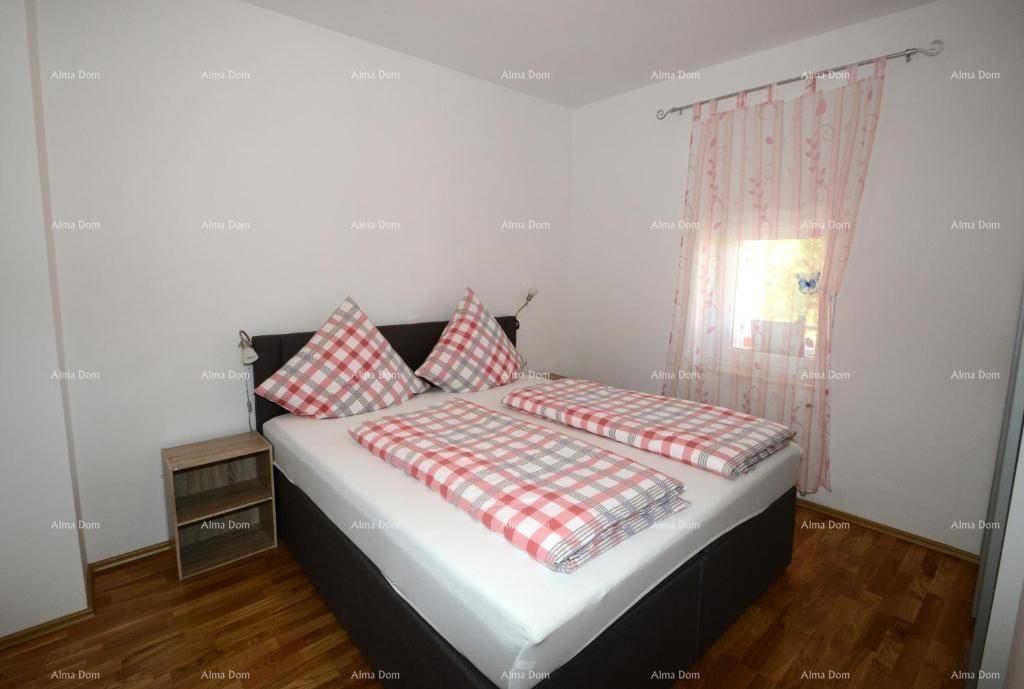Gemütliches Schlafzimmer mit Doppelbett, Holzfußboden und Fenster.