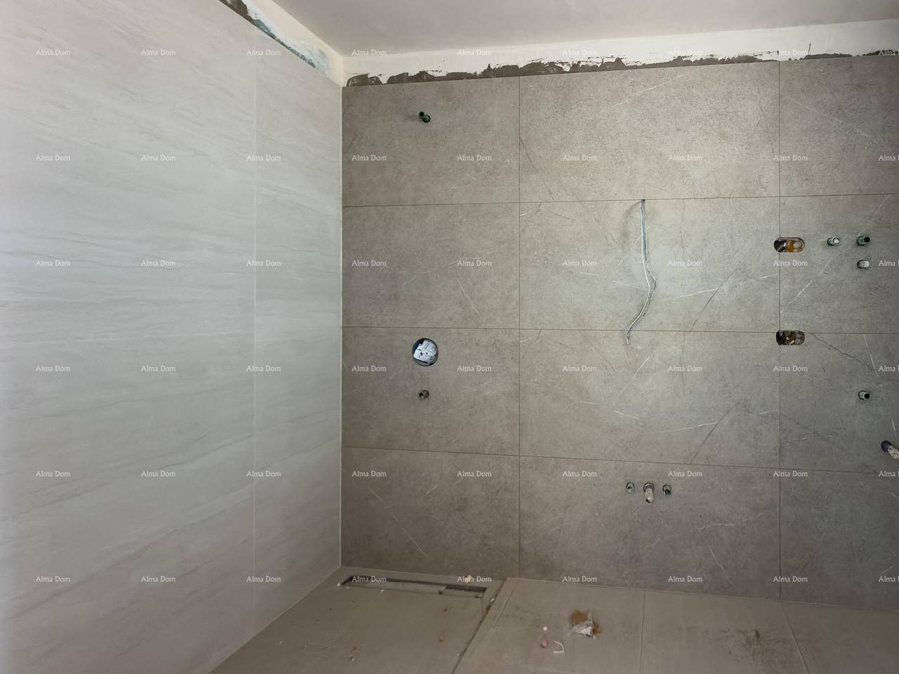 Unfertiges Badezimmer mit modernen grauen und weißen Fliesen, bereit für die Installation der Sanitärobjekte.