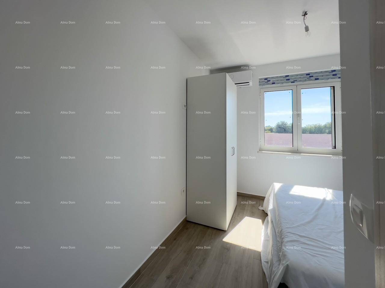 Helles Schlafzimmer mit Einzelbett, Kleiderschrank und Fenster, das viel Tageslicht hereinlässt.