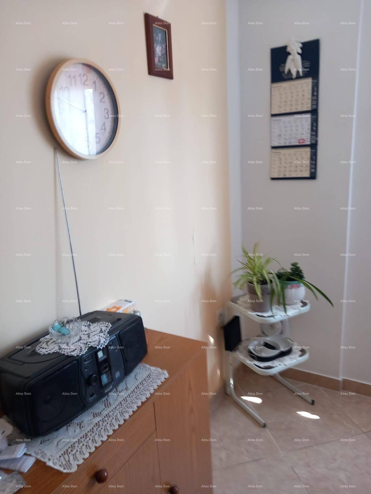 Ecke eines Raumes mit Radio, Uhr und Pflanze, auf einem Fliesenboden stehend.