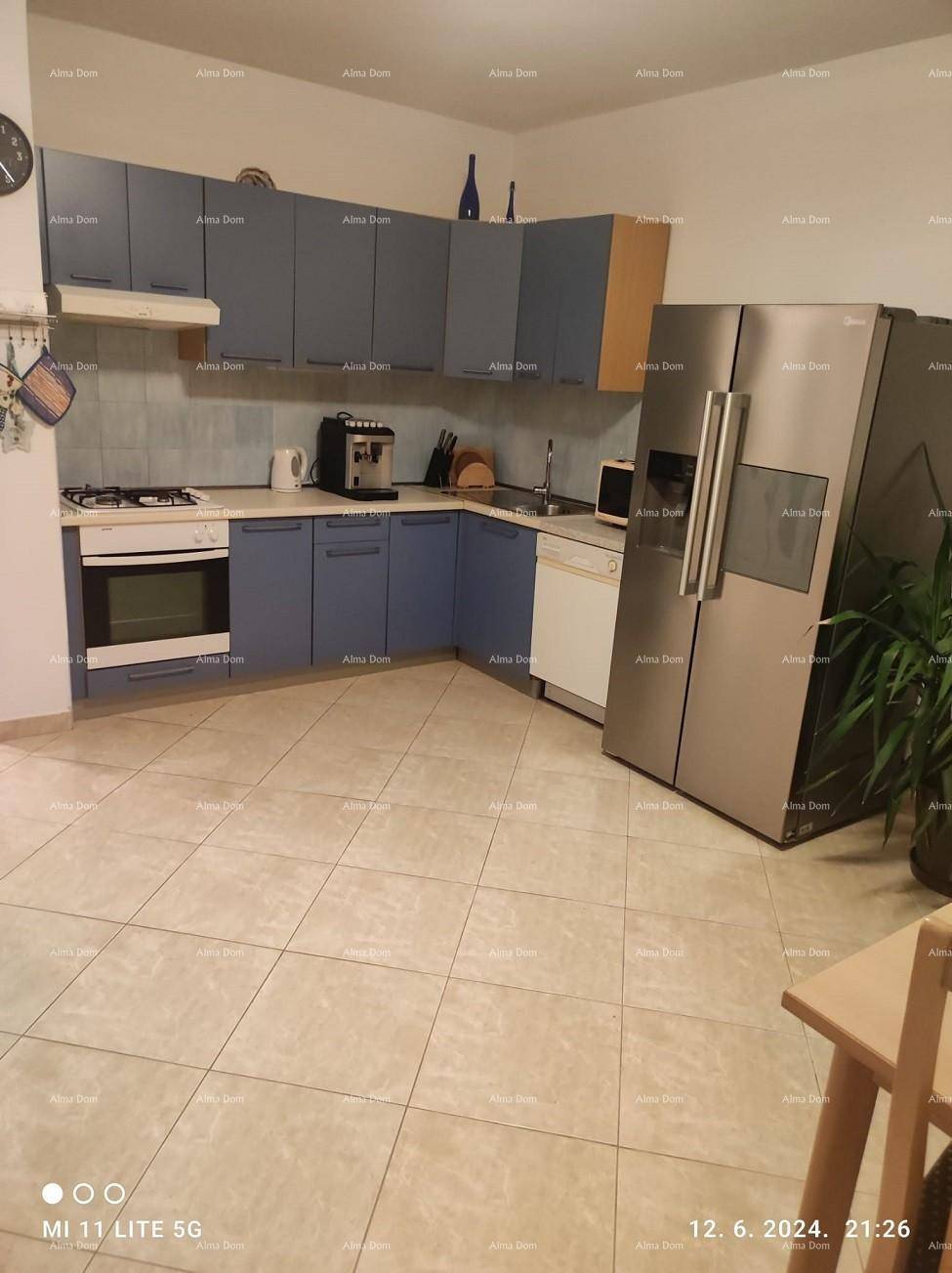 Geräumige Küche mit blauen Schränken, Fliesenboden und großem Kühlschrank mit Gefrierfach.