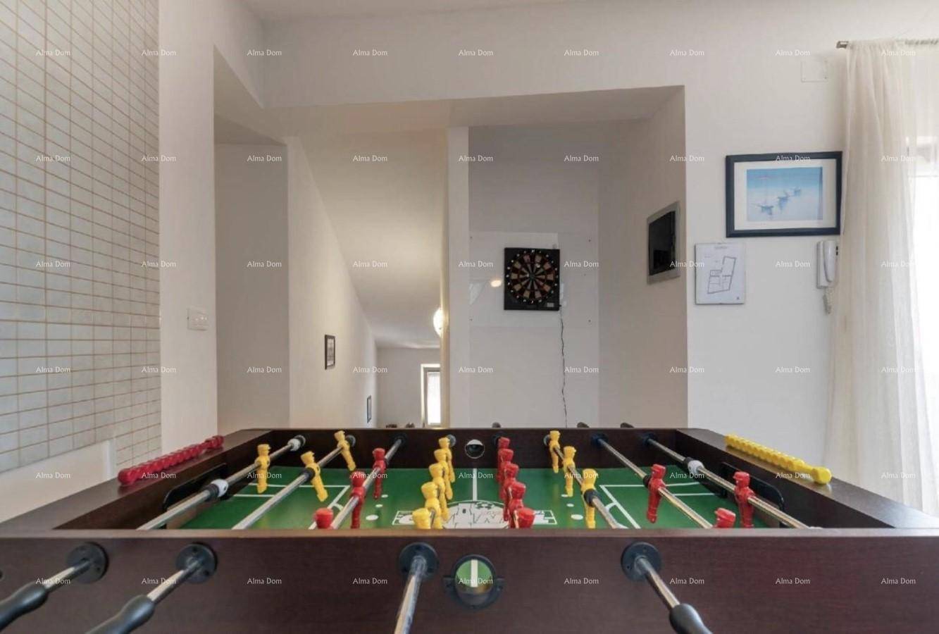 Kicker-Tisch in einem hellen Raum mit Blick auf den Flur und eine Dartscheibe.
