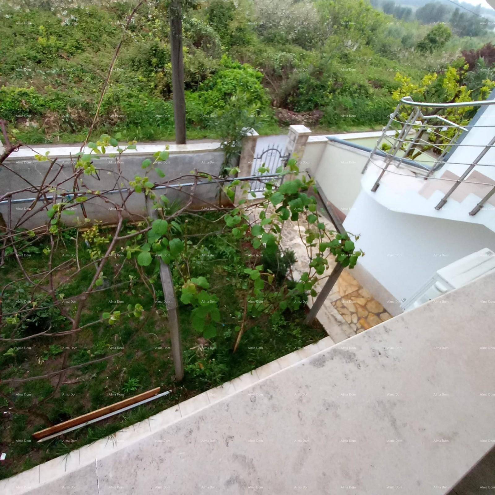 Kleiner Gartenbereich mit Pflanzen und einer Außentreppe, die zu den oberen Etagen führt.