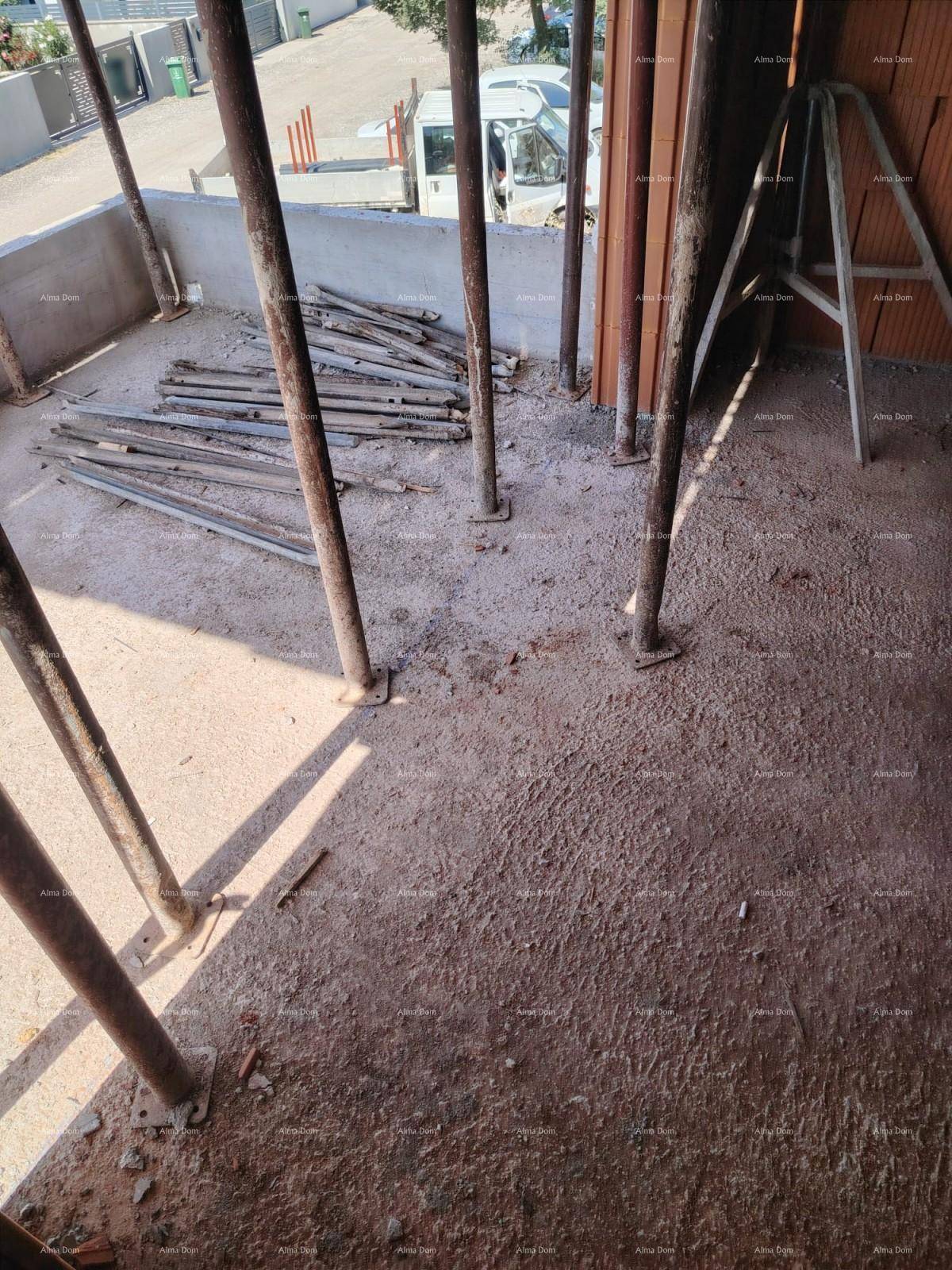 Blick auf den Rohboden einer Baustelle mit Metallstützen und Baumaterialien.