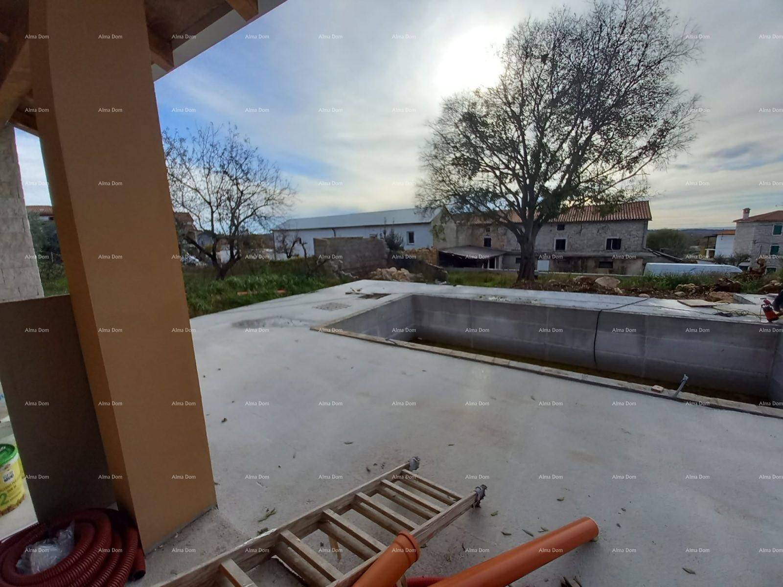 Außenbereich im Bau mit unfertigem Pool und Blick auf die Umgebung.