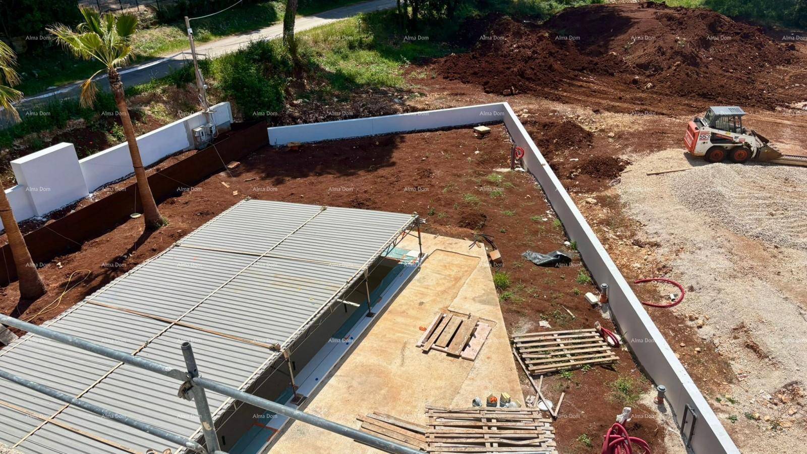 Luftaufnahme einer Baustelle mit Rohbau des Pools und Erdarbeiten im umliegenden Gelände.