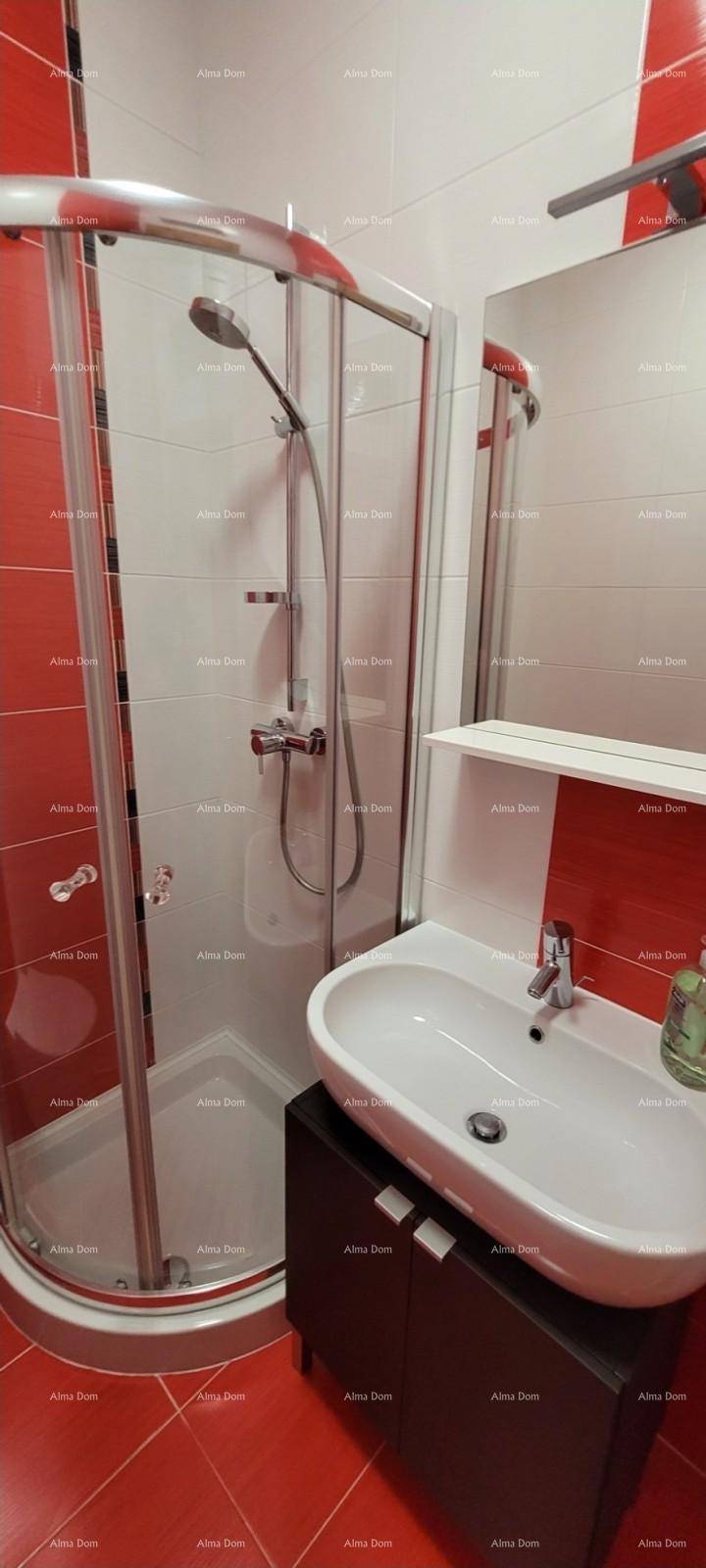 Modernes Badezimmer mit Duschkabine, Waschbecken und auffälligen rot-weißen Fliesen.