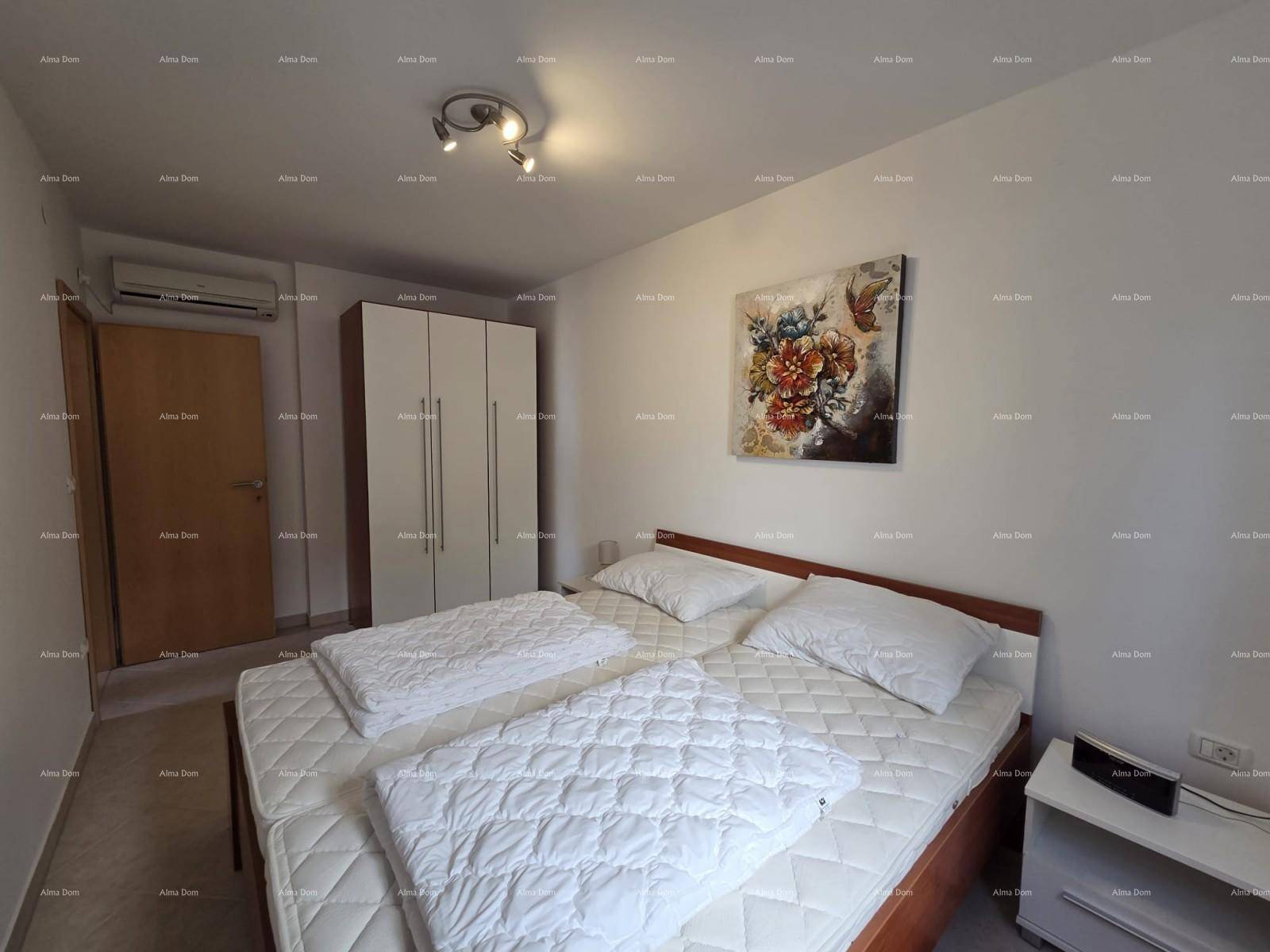Schlafzimmer mit Doppelbett, weißem Kleiderschrank und installierter Klimaanlage.