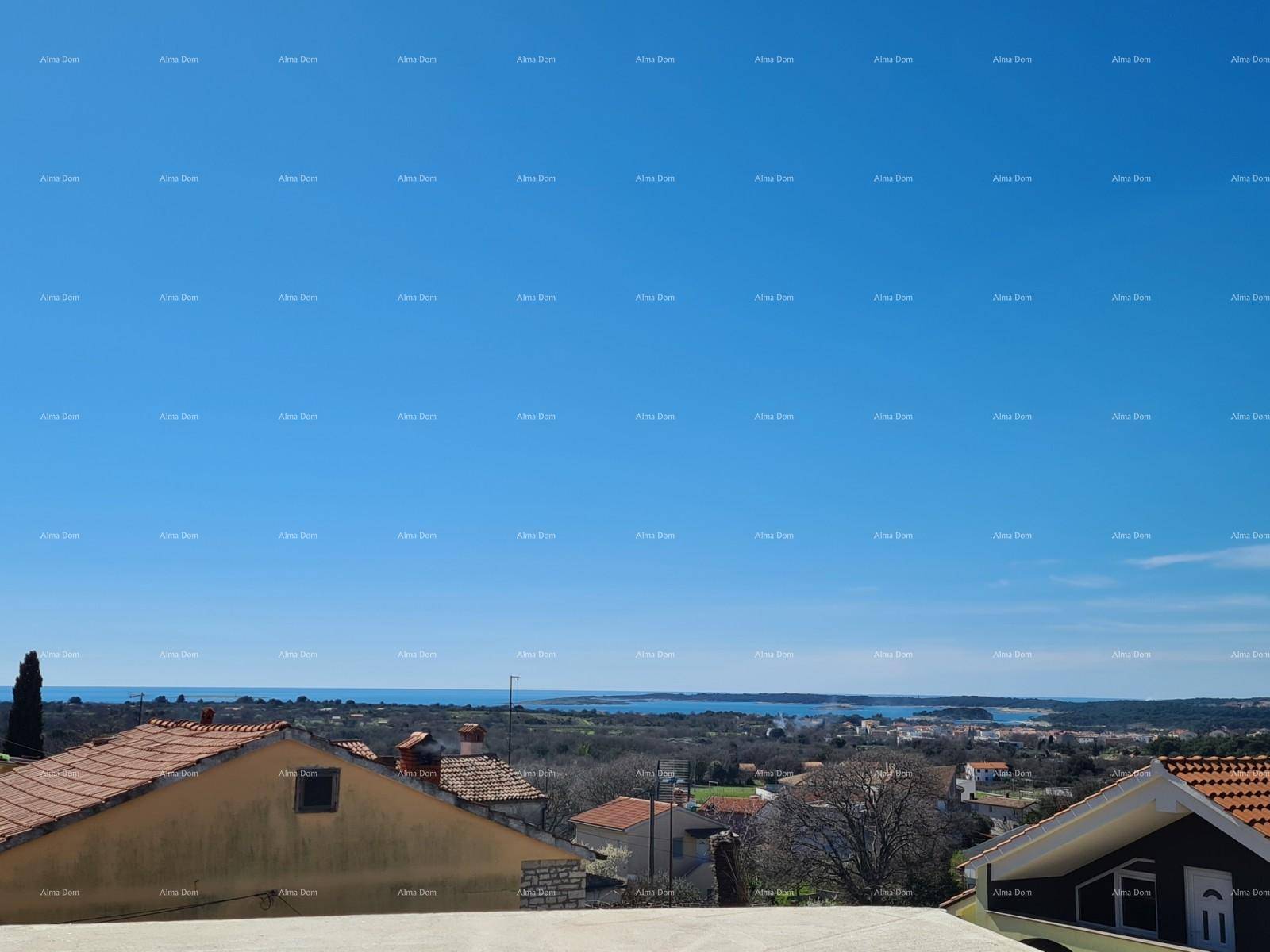 Ausblick auf die umliegende Landschaft mit Häusern und dem Meer in der Ferne.
