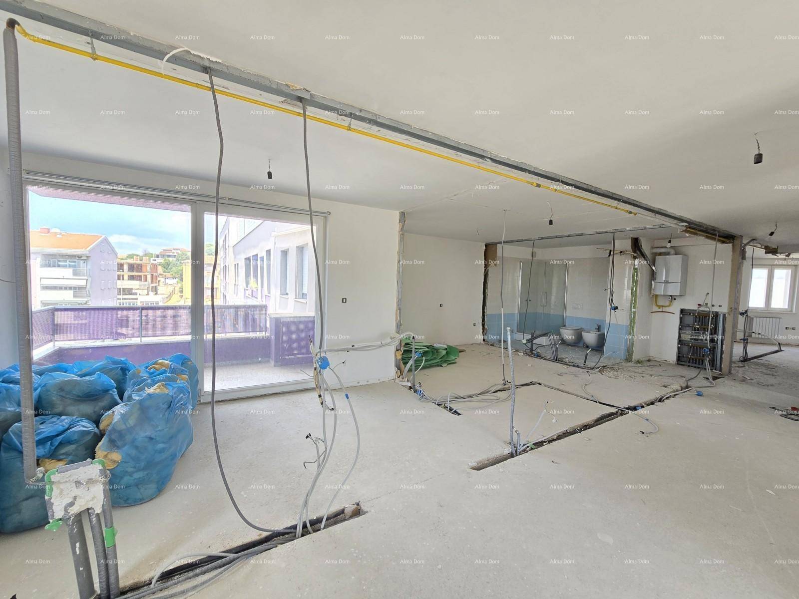Offener Innenraum im Rohbau mit sichtbaren Leitungen und Zugang zu einem Balkon.