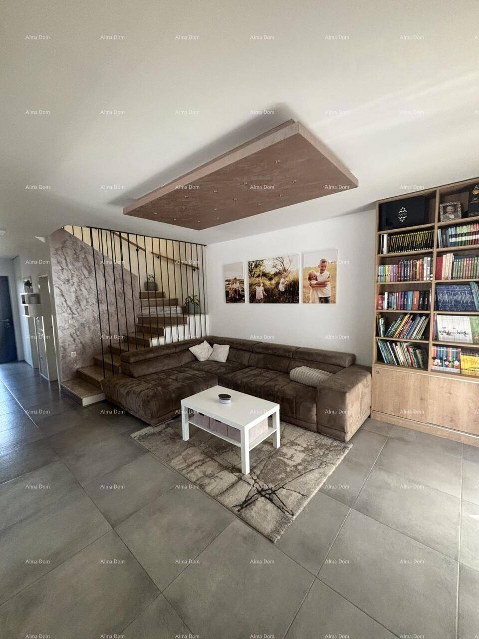Helles Wohnzimmer mit großem Ecksofa, Fliesenboden und dekorativer Deckenbeleuchtung.