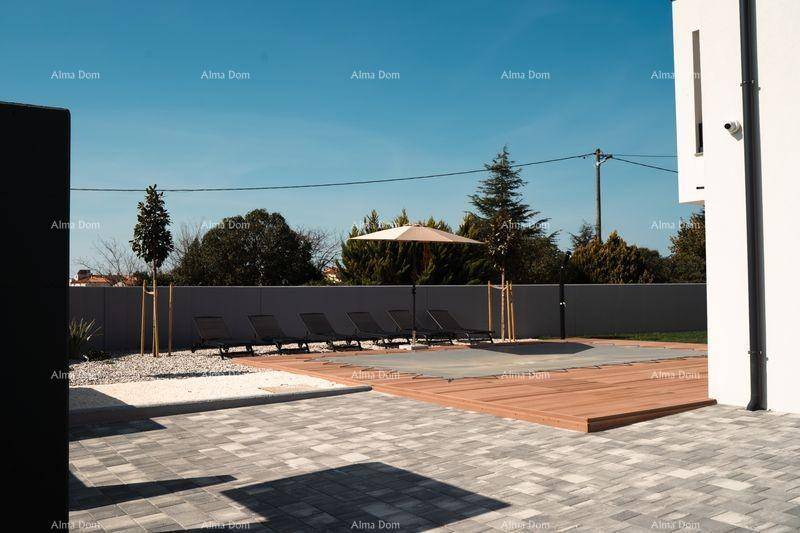 Weitläufiger Außenbereich mit gepflastertem Weg, Pool, Sonnenliegen und umgebender Bepflanzung.