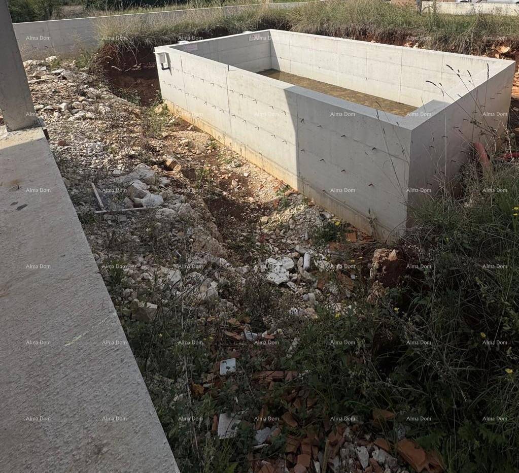 Baustelle mit dem Fundament eines zukünftigen Pools, umgeben von unberührter Natur und Schutt.