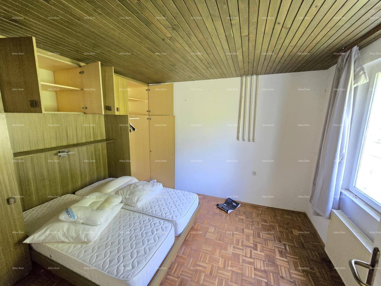 Schlafzimmer mit zwei Einzelbetten, Einbauschränken und Holzdach, einfach und funktional.